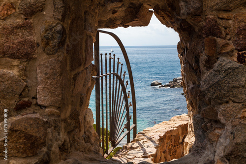 Exit to the beach by the walls of the so-called demon hole. Exit to the beach by a hollow in a wall in the town of Tossa de mar, Spain. photo