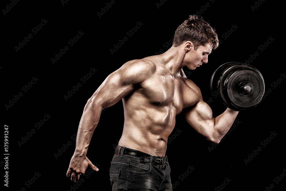 Athletic shirtless young sports man - fitness model holds the dumbbell in gym. Copy space fore your text.