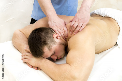 The process of sports massage is done by a man in a massage salon 