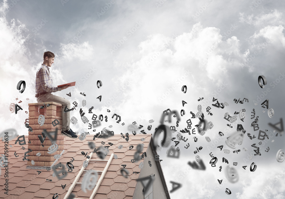 Man on brick roof reading book and symbols flying around Man on brick roof reading book and symbols flying around