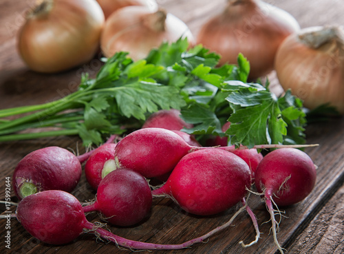 radishes parsley and onions on a kitchen table