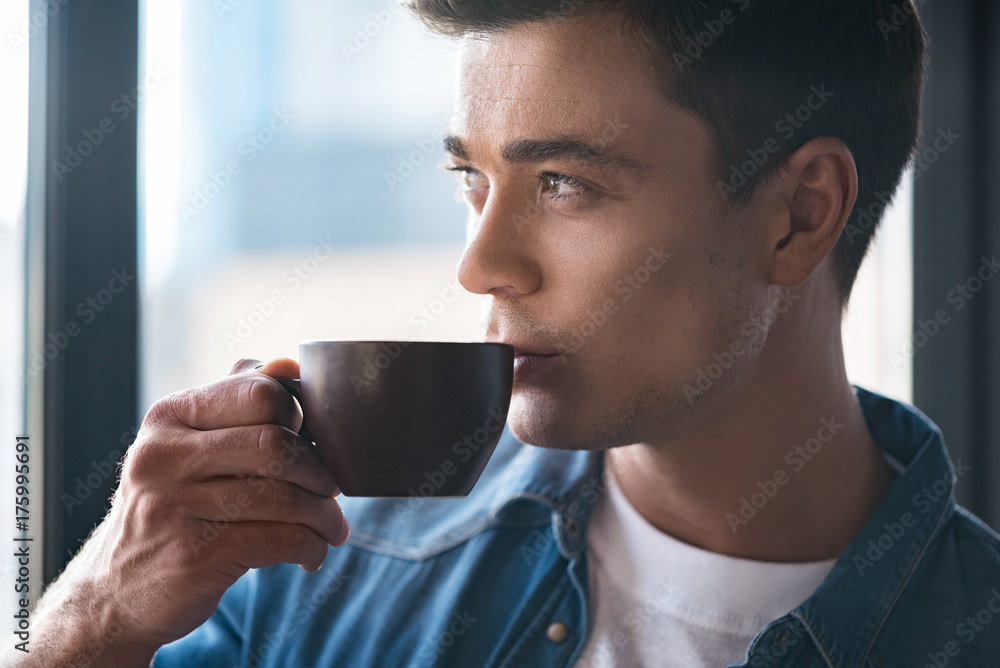 Charming cute young man is enjoying espresso Charming cute young man is enjoying espresso