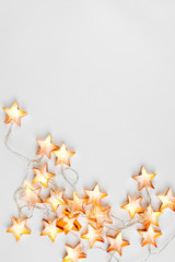 Warm star-shaped light garlands, festive decorations with copy space.  Christmas concept. Flat lay, top view