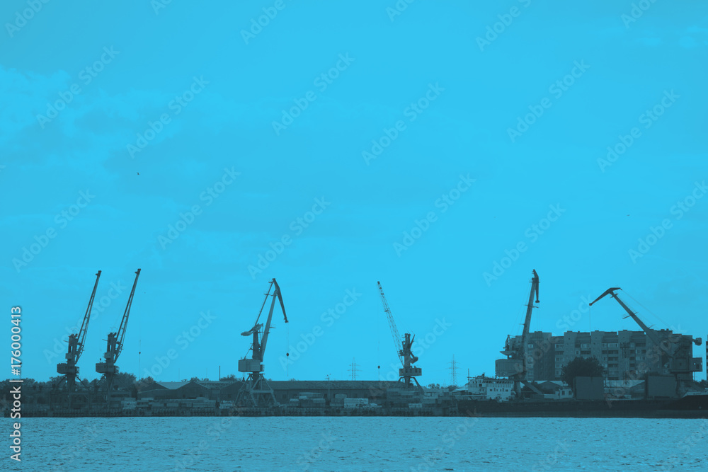 Cargo ship-lifting cranes on the river in the port Toned