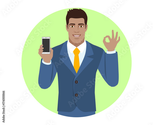 Businessman holding mobile phone and show a okay hand sign