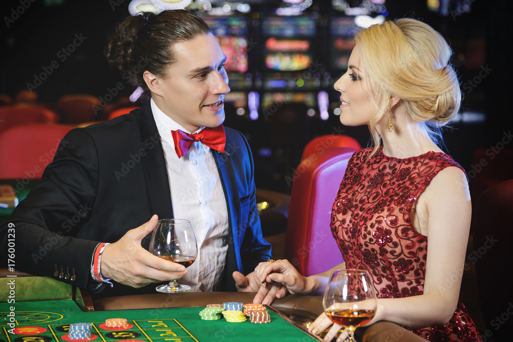 Fototapeta premium Beautiful and rich couple playing roulette in the casino