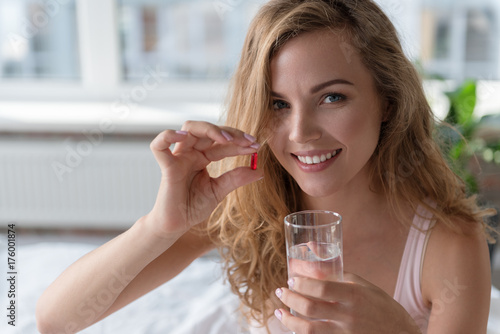 Glad smiling lady holding pill