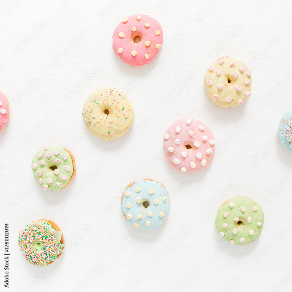 Colorful donuts on white background. Flat lay, top view minimal pattern. Colorful donuts on white background. Flat lay, top view minimal pattern.
