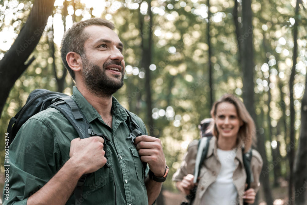 Joyful couple walking in the woods with enjoyment Joyful couple walking in the woods with enjoyment