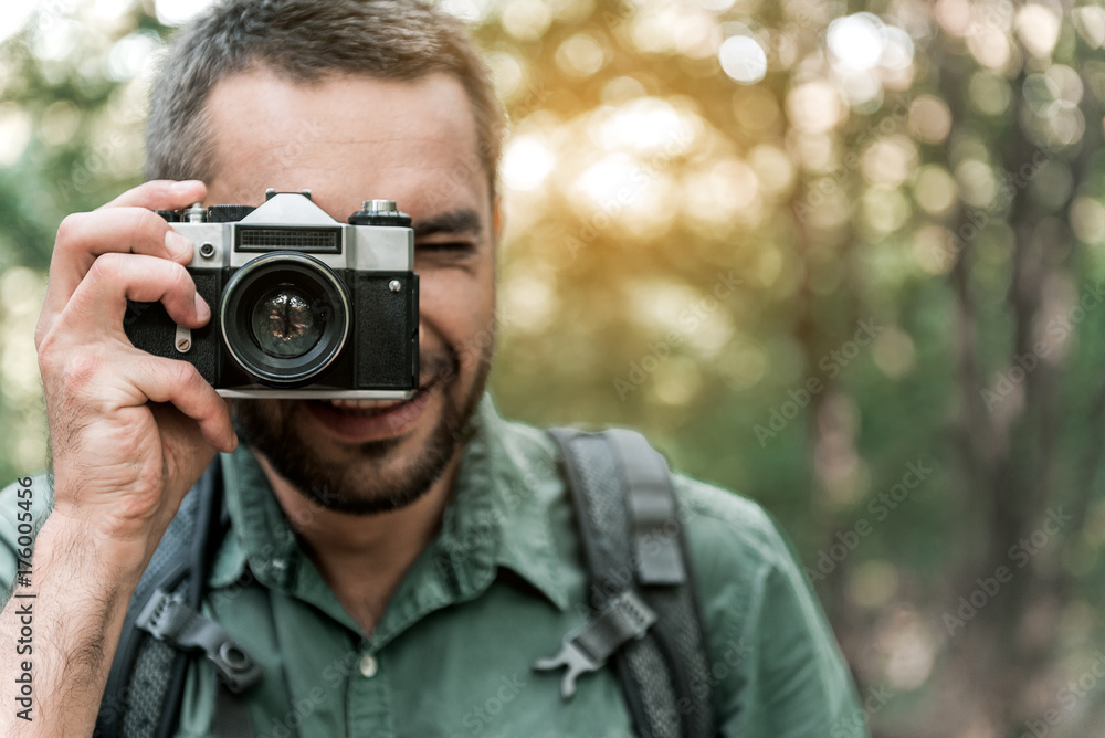Happy man photographing nature in the woods Happy man photographing nature in the woods