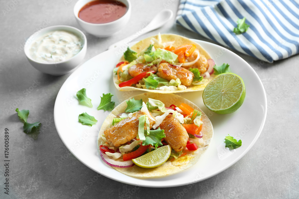 Plate with delicious fish tacos on table Plate with delicious fish tacos on table