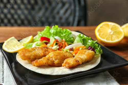 Plate with delicious fish taco on table, closeup