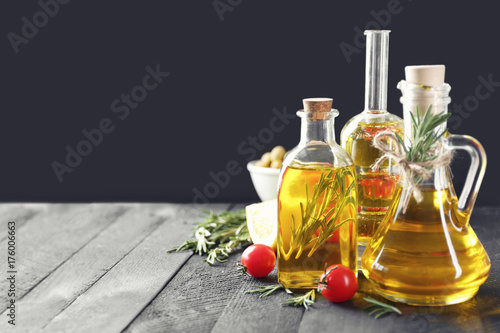 Composition with rosemary oil and tomatoes on wooden table
