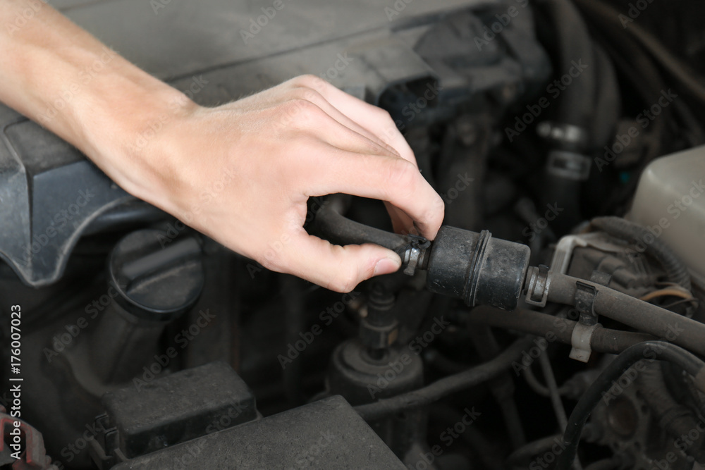 Young mechanic repairing car in body shop Young mechanic repairing car in body shop