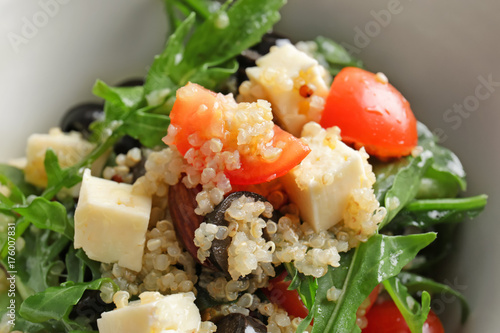 Salad with quinoa, vegetables and cheese in bowl, closeup