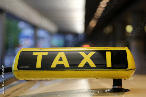 Taxischild auf Autodach mit Spiegelung, Schlange am Flughafen