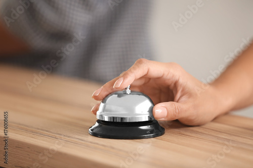 Woman ringing service bell at hotel reception