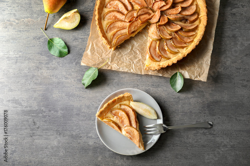 Composition with tasty pear tart on table photo