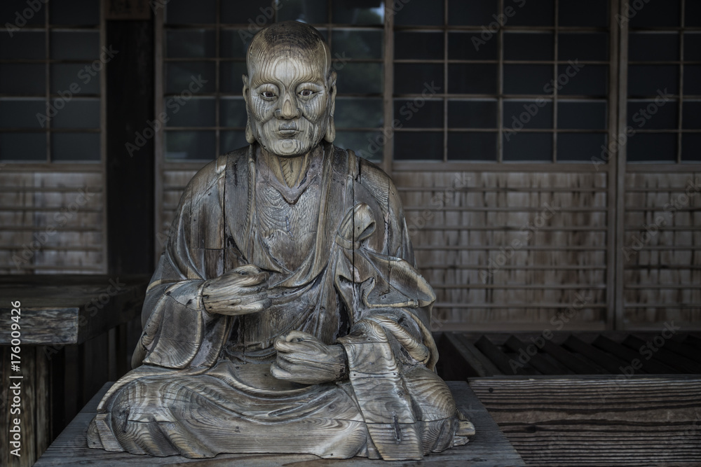 Wooden statue of a monk at wooden shrine itsukushimam, Miyajima, Japan Wooden statue of a monk at wooden shrine itsukushimam, Miyajima, Japan