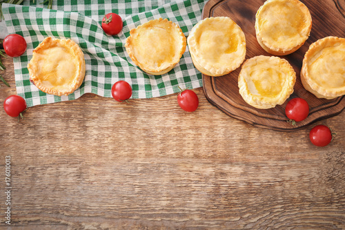 Delicious little meat pies on wooden table