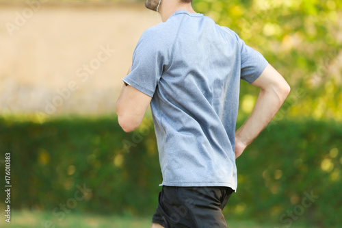 Sporty young man running outdoors © Africa Studio