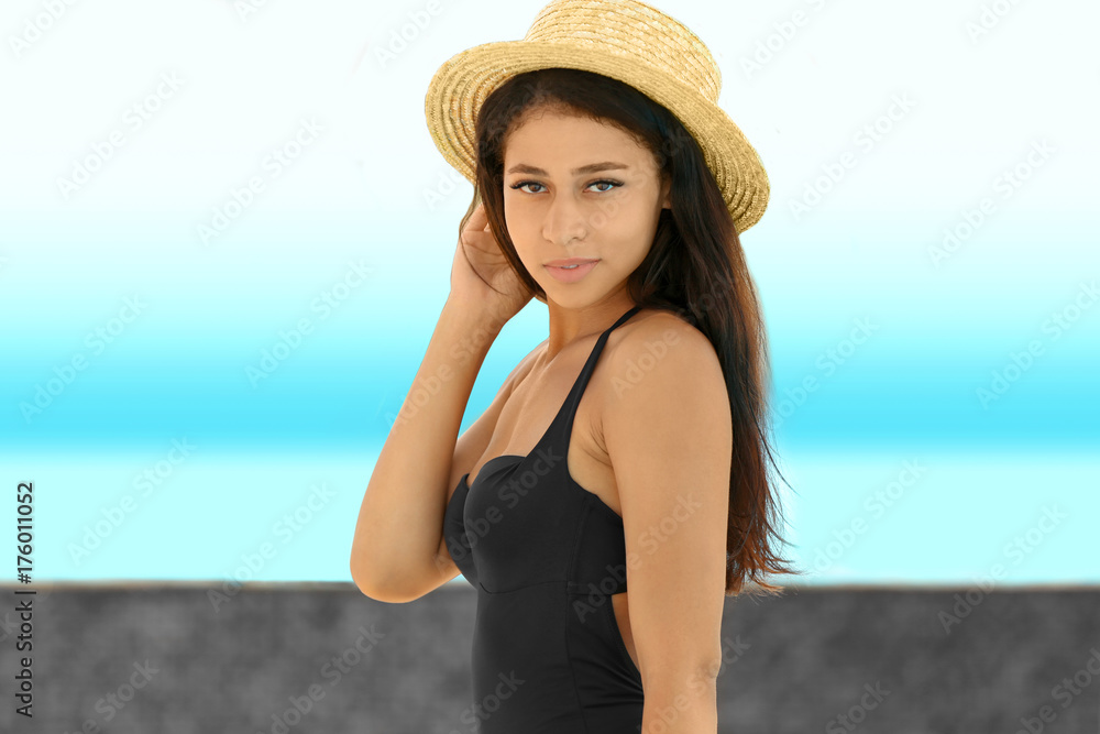 Beautiful young woman in bikini near swimming pool
