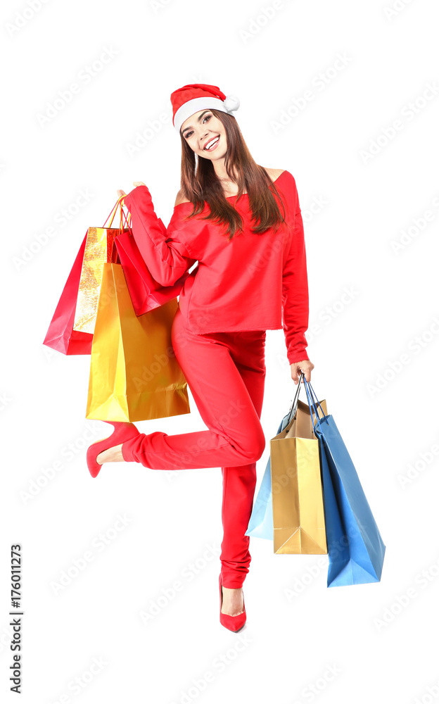 Beautiful young woman in Santa Claus hat and with bags on white background. Christmas shopping concept Beautiful young woman in Santa Claus hat and with bags on white background. Christmas shopping concept
