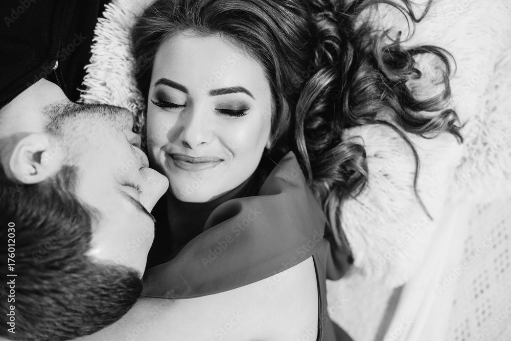 Fototapeta premium Tenderly kissing couple. Man and woman lying towards down. Kiss
