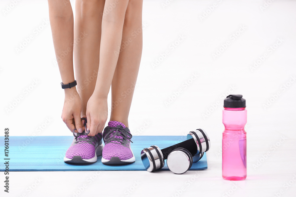 Φωτογραφία Young sporty woman tying shoelaces in gym