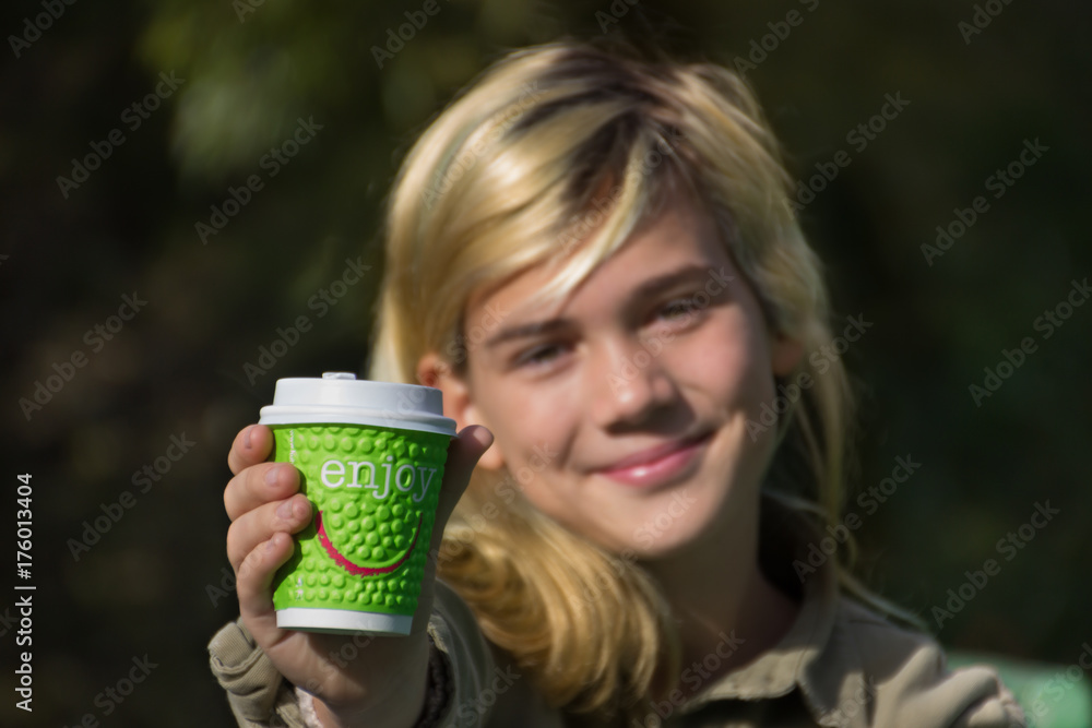 Cheerful girl holds a coffee Cup with the inscription Cheerful girl holds a coffee Cup with the inscription