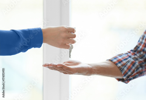 Hand of real estate broker giving customer key from new flat