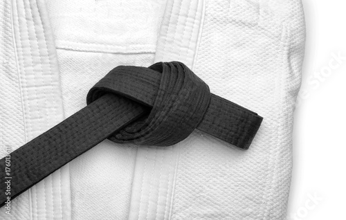 Karate uniform with black belt on white background, closeup