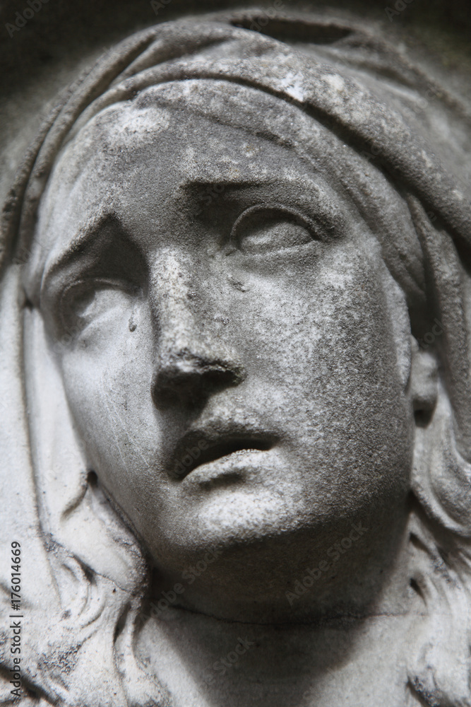 Virgin Mary statue. Vintage sculpture of sad woman (Religion, faith, suffering, love concept)
