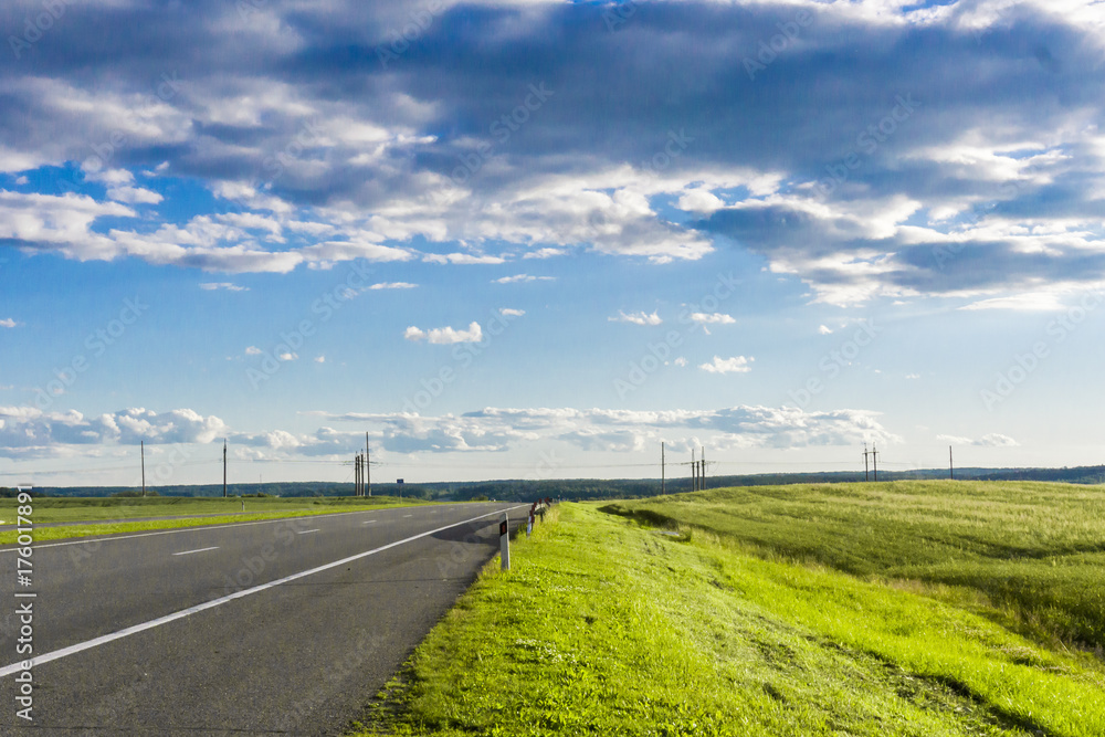 Green field road. Car journey in the Belarus.
