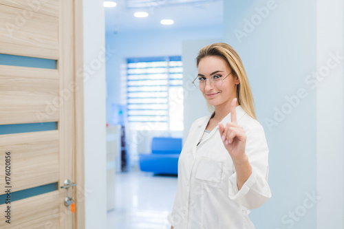 Medical doctor woman smile, nurse wear white surgery suit, point finger up, concept of advertisement product, empty copy space.Over hospital interior Free Download Medical doctor woman smile, nurse wear white surgery suit, point finger up, concept of advertisement product, empty copy space.Over hospital interior - GFXLoad