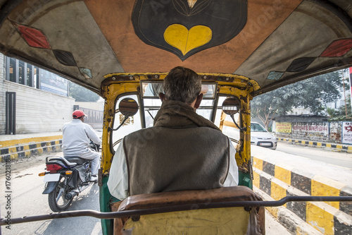 A rickshaw (also known as Tuc Tuc) driver is driving in the streets of Agra in India. Agra is a city on the banks of the river Yamuna in the northern state of Uttar Pradesh photo