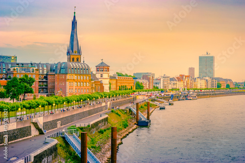 A view at the city skyline central Dusseldorf from the rhine river  Dusselfdorf Germany. Colorful panorama of german city at sunset.