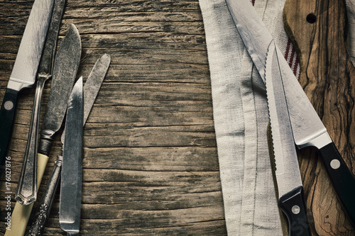 Old knives and Chopping board on wooden background, top view, copy space
