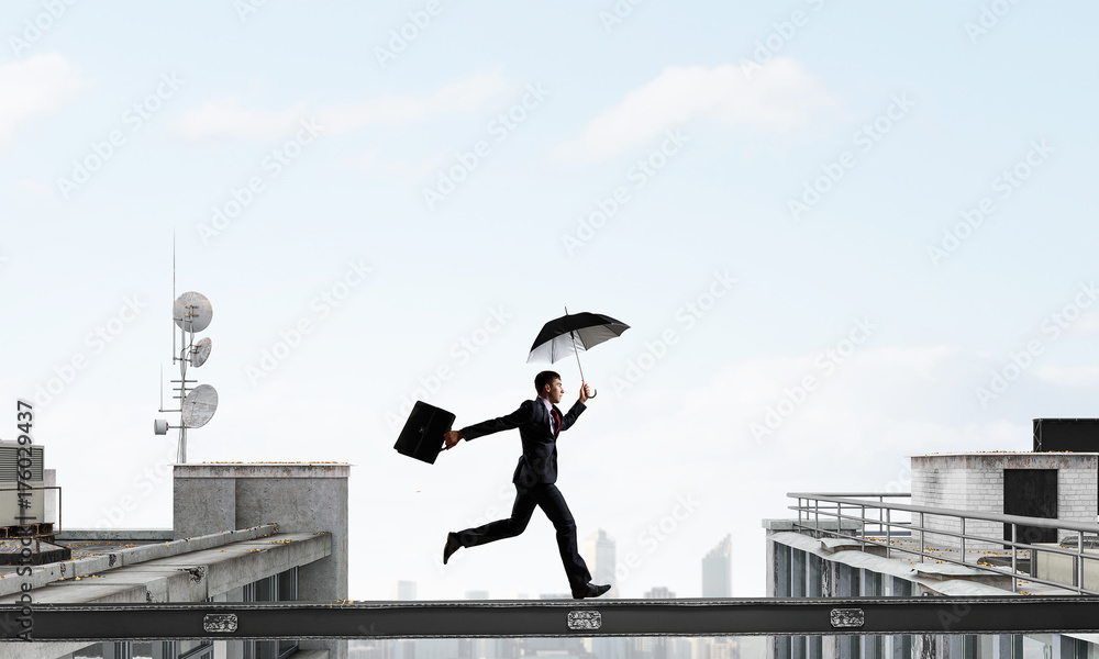 Fearless businessman overcoming difficulty. Mixed media Fearless businessman overcoming difficulty. Mixed media