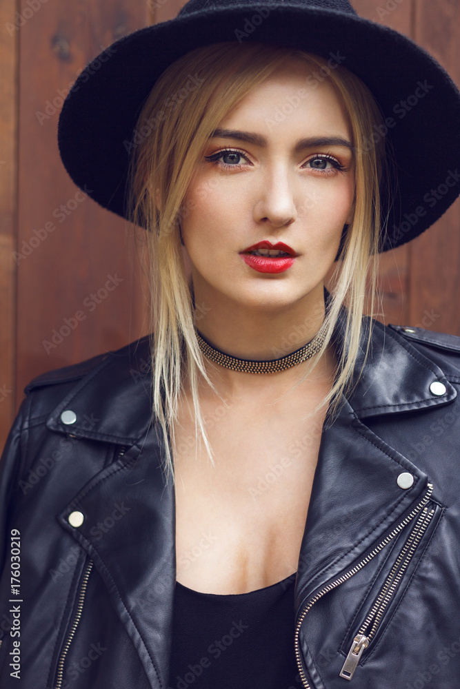 Close up of most beautiful young woman with gorgeous long blonde hair is  looking at you. Wearing leather jacket, fashionable black hat and choker  around neck. Stock Photo | Adobe Stock
