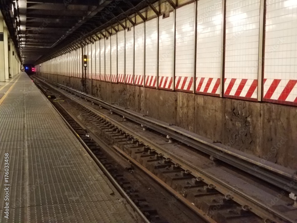 Underground subway platform with train tracks in a tunnel