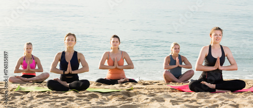 Glad women making yoga meditation in lotus pose