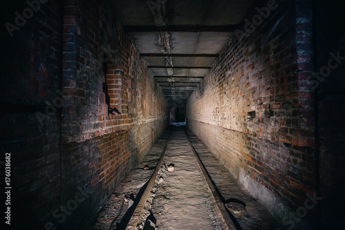 Dark scary corridor in abandoned industrial ruined brick factory, creepy interior photo
