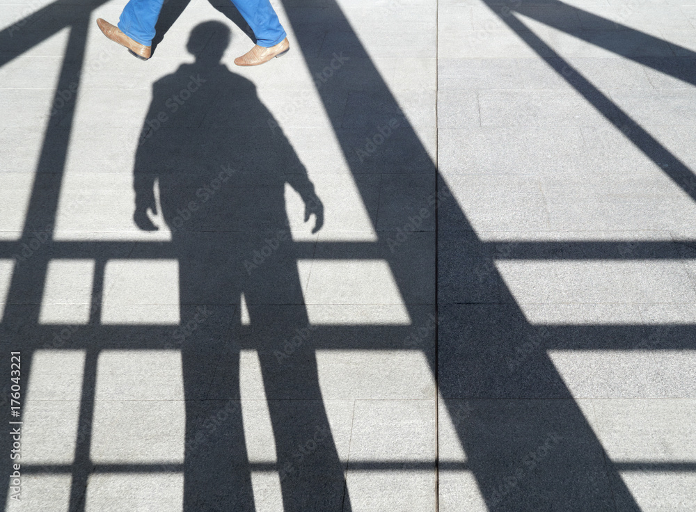 shadow of a man on the sidewalk among the beams, visible someone's feet shadow of a man on the sidewalk among the beams, visible someone's feet