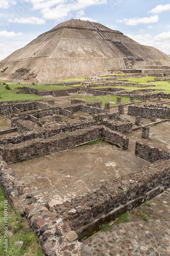 ancient Aztec ruin structures with the Pyramid of the Sun in the background at Teotihucan Mexico  photo