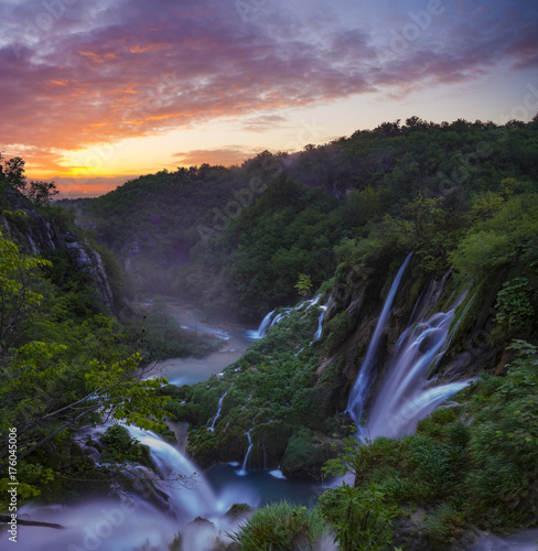 foggy and multicolored dawn over beautiful waterfalls in the park of plitvice lakes in croatia