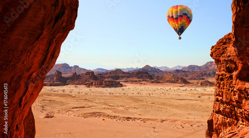 Colorful hot air balloon flight in the blue sky in beautiful landscape of multicolored stony desert with rocks. Timna geological park. Israel
