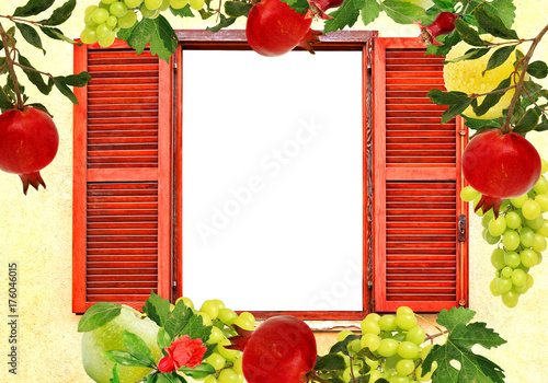 Rural window with open wooden shutters. Decorative frame of ripe fruit. Pomegranates, apples and grapes. Fall harvest. Free white isolated space inside