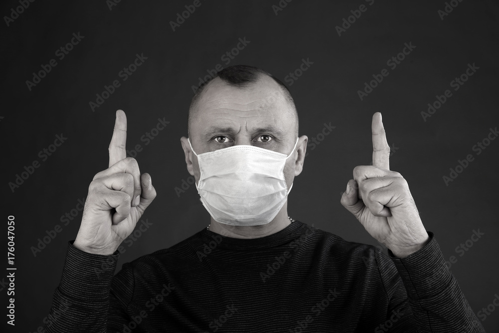 man in a black T-shirt and a medical mask man in a black T-shirt and a medical mask