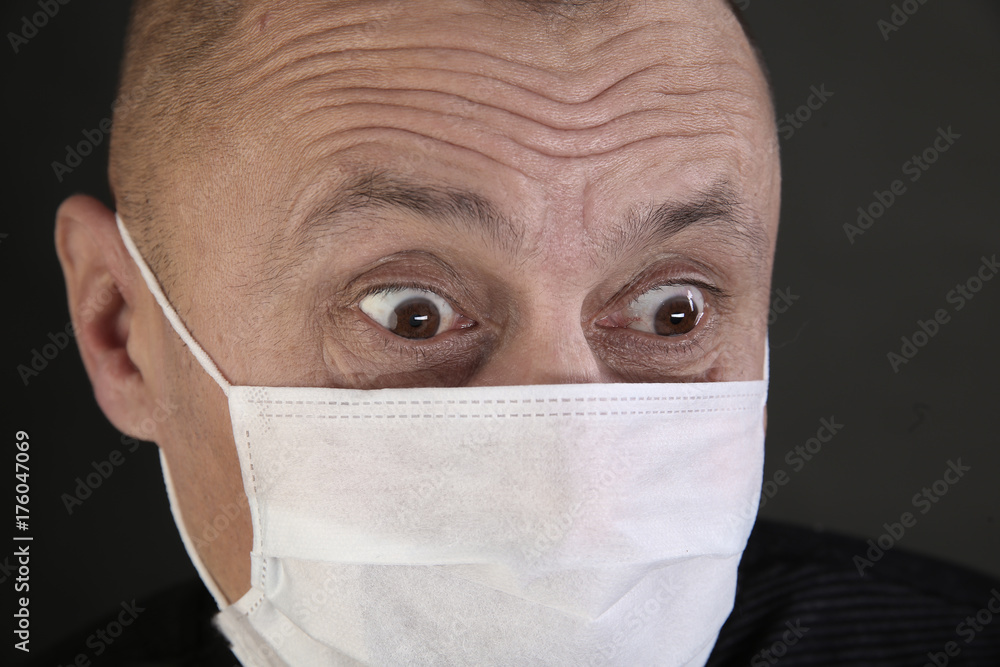 man in a black T-shirt and a medical mask man in a black T-shirt and a medical mask